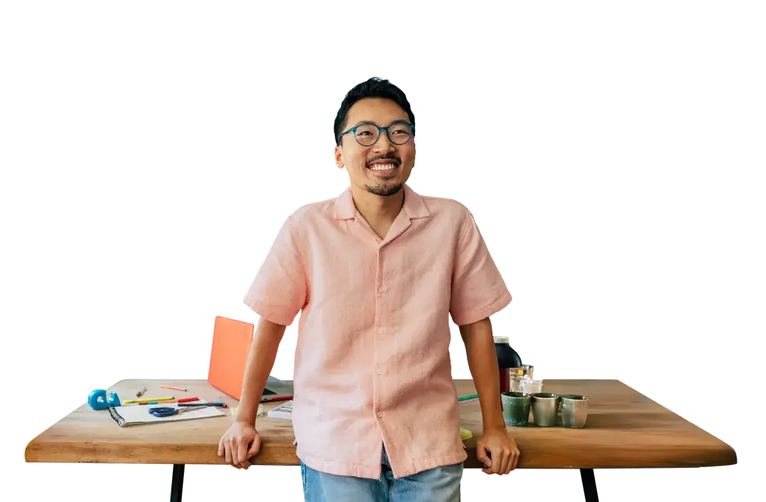 A smiling man leaning on a desk
