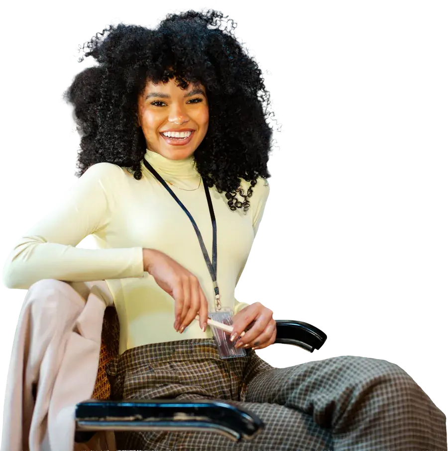 A smiling woman with a lanyard, sitting back in her chair
